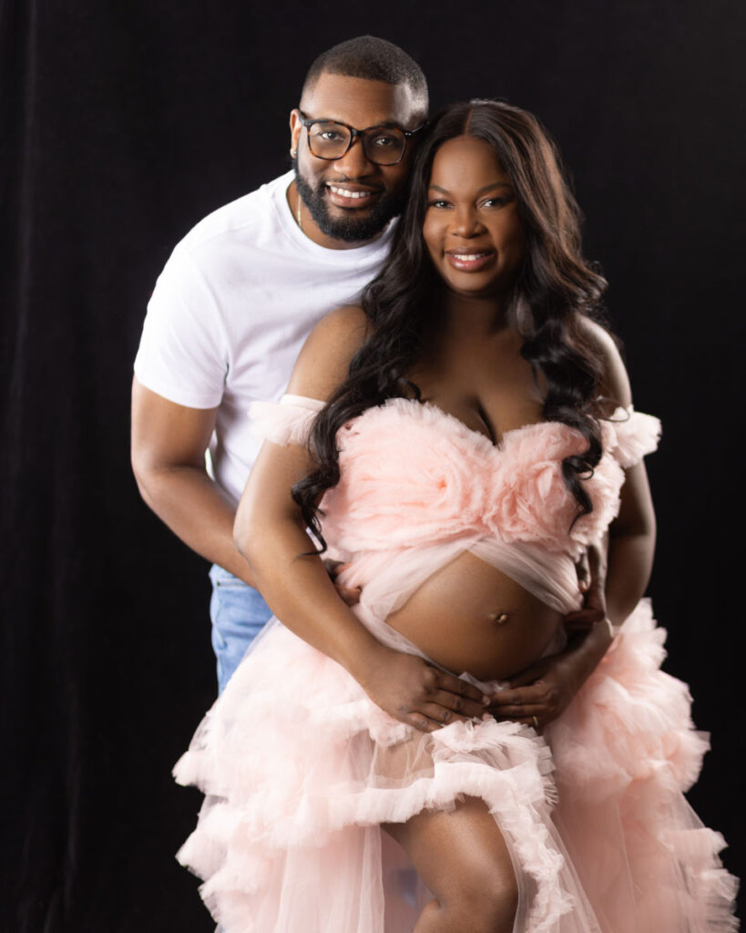 Pregnant mother wearing a soft pink gown during a studio maternity portrait session