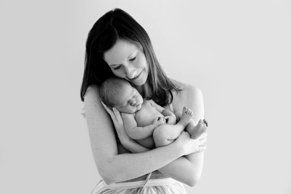 Parents holding newborn baby during studio family portrait session.