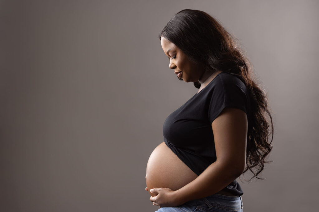 Pregnant woman posing in profile during a professional maternity photography session