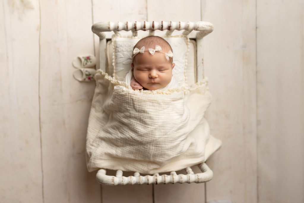 Peacefully sleeping newborn wrapped in a soft cream blanket during a studio newborn photo session at Alternate Angles Photography in Norwood, serving Greater Boston families.