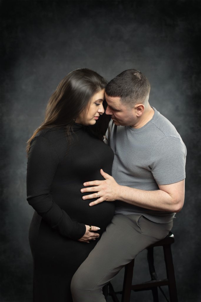 Expecting couple sharing a quiet moment during a Boston maternity photography session.