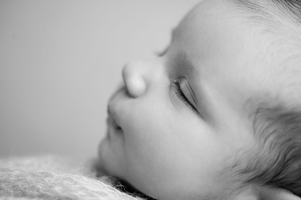 Black-and-white close-up profile of a sleeping newborn baby's face